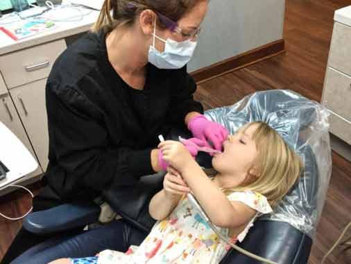 Child with Hygienist at Apex Dental Group in Apex, NC Child with Hygienist at Apex Dental Group in Apex, NC